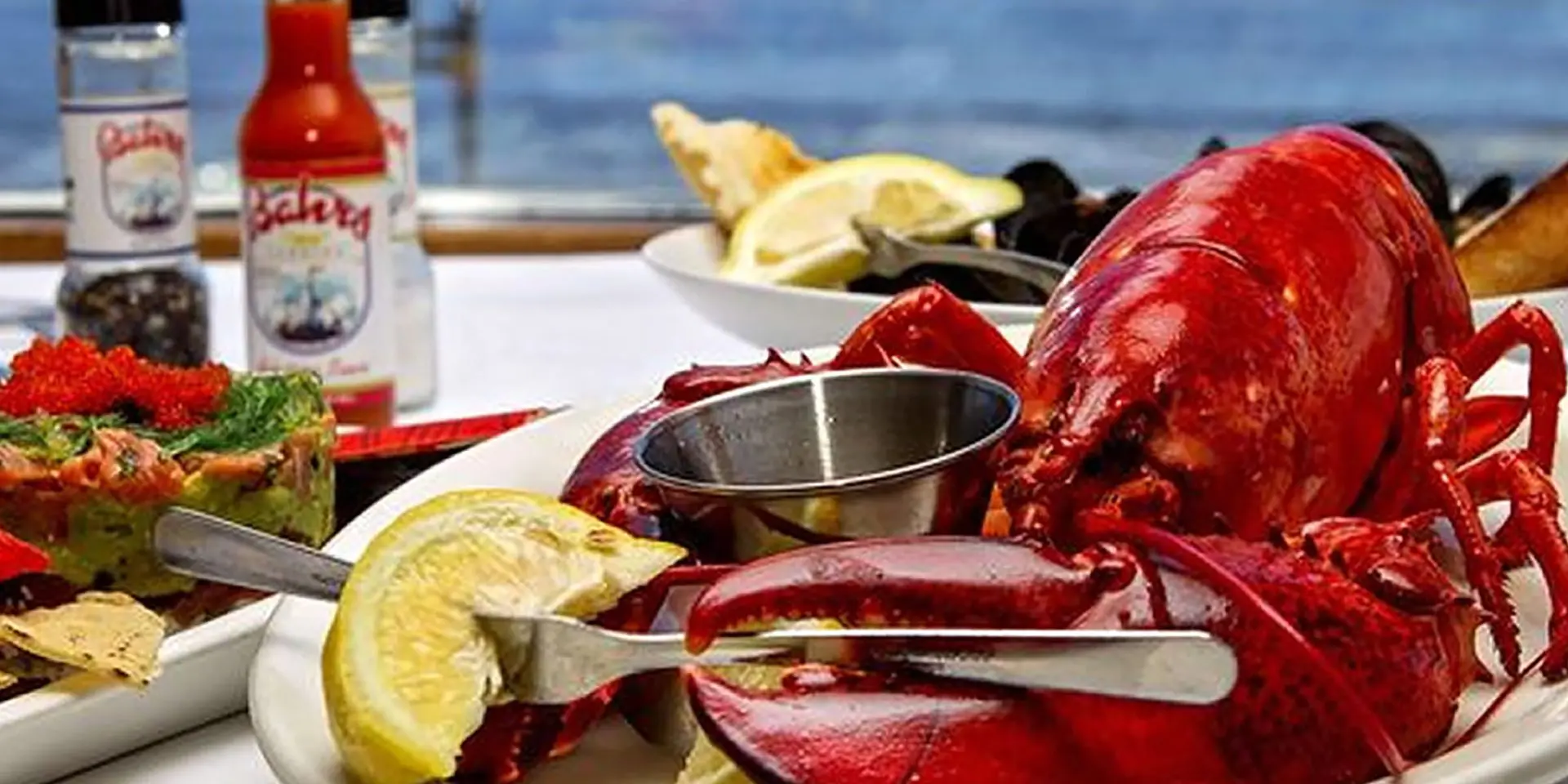 A lobster dinner with lemon and other seafood.