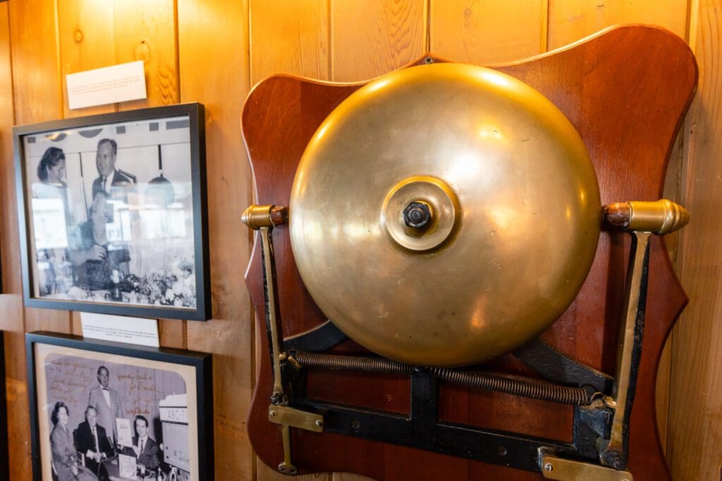 A large bell mounted to the wall in a room.