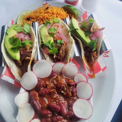 A White Plate With Tacos and Gravy