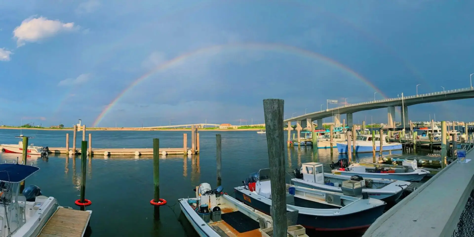 A rainbow over boats in the water.